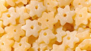 Uncooked Stelline Pasta. A Culinary Canvas of Stelle Macaroni, Creating a Lively and Textured Background for Gourmet Cooking - Top View, Rotating. Turning Dry Pasta. Raw Macaroni - Rotation video