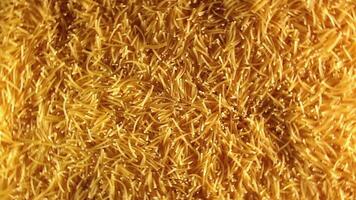 Background of Uncooked Golden Noodles that Rotating Clockwise - Top View. Texture of Dry Vermicelli Turning Around. Raw Pasta with Low Key Light - Right Rotation video
