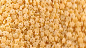 Uncooked Stelline Pasta. A Culinary Canvas of Stelle Macaroni, Creating a Lively and Textured Background for Gourmet Cooking - Top View, Rotating. Turning Dry Pasta. Raw Macaroni - Side Rotation video