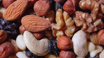 Mixed Nuts. Almonds, Walnuts, Cashews, Peanuts, Hazelnuts, Dried Prunes and Raisins - Rotating, Top View. Different Nut Mix Turning. Background from Various Nuts and Dried Fruits - Rotation video