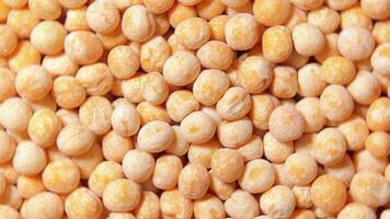 Uncooked Yellow Polished Peas. A Culinary Canvas of Dry Yellow Peas, Textured Background - Top View, Rotating. Turning Scattered Raw Polished Peas. Healthy Eating Ingredients - Rotation video
