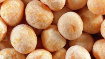 Uncooked Yellow Polished Peas. A Culinary Canvas of Dry Yellow Peas, Textured Background - Top View, Rotating. Turning Scattered Raw Polished Peas. Healthy Eating Ingredients - Rotation video