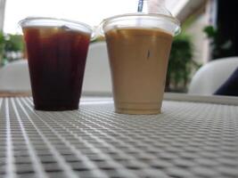 Two drinks sitting on a table photo
