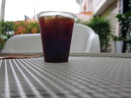 A cup of iced coffee sitting on a table photo
