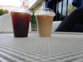 Two drinks sitting on a table photo