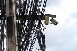 A bunch of wires and a camera on a pole photo
