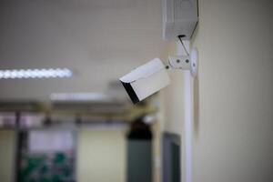 A security camera mounted on the wall of a building photo