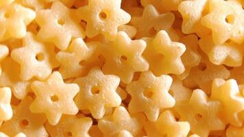 Uncooked Stelline Pasta. A Culinary Canvas of Stelle Macaroni, Creating a Lively and Textured Background for Gourmet Cooking - Top View, Rotating. Turning Dry Pasta. Raw Macaroni - Rotation video