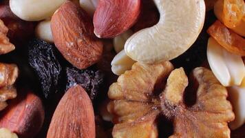 Mixed Nuts. Almonds, Walnuts, Cashews, Peanuts, Hazelnuts, Dried Prunes and Raisins - Rotating, Top View. Different Nut Mix Turning. Background from Various Nuts and Dried Fruits - Rotation video