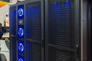 A man standing in front of a large server rack photo