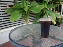 A glass table with a cup of coffee sitting on it photo