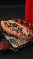 Hotdog with grilled sausage with bacon and mushrooms in a bun with salt, spices and herbs video