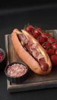 Hotdog with grilled sausage with bacon and mushrooms in a bun with salt, spices and herbs video
