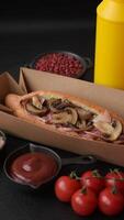 Hotdog with grilled sausage with bacon and mushrooms in a bun with salt, spices and herbs video