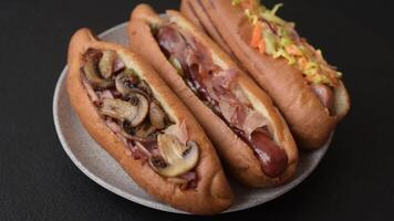 Hotdog with grilled sausage with bacon and mushrooms in a bun with salt, spices and herbs video
