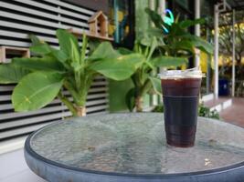 A glass table with a drink on it photo