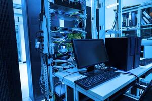 A computer desk in a server room photo