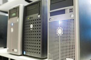 Several dell servers are lined up on a shelf photo