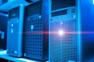 A row of computer servers with a red light shining on them photo