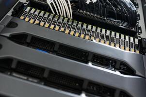 A close up of a server rack with multiple cables photo