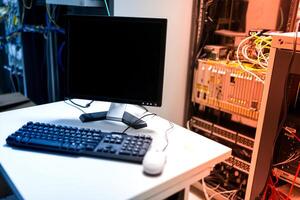 A computer monitor and keyboard on a desk photo