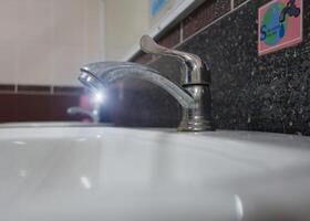 A sink with a faucet and a mirror photo