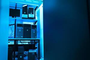 A computer room with several computers and a blue light photo