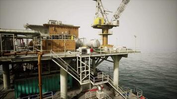 Old oil platform construction and operations at sea during a cloudy day video