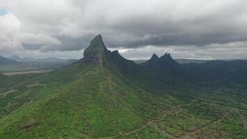 shooting from top to bottom the peaks of mountains and jungles of Mauritius, the sky in clouds photo