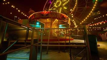 Empty amusement park at night with illuminated rides and colorful lights video