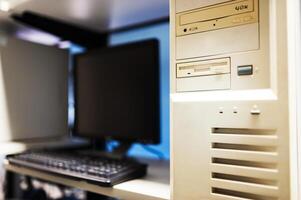 A computer monitor and keyboard are sitting on a desk photo