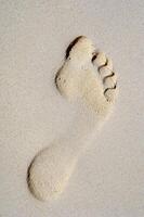 Footprint in sand on beach photo