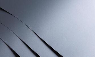 Fine textured designer paper background with a smooth, metallic gradient in monochrome gray. This photo