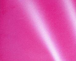 Glossy pink background with a bright, shiny texture and soft shimmer, creating a stylish and modern photo