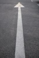 Macro photography of asphalt road texture with vertical arrow close up photo