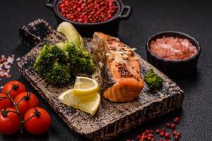 Grilled salmon with salt and spices, broccoli, tomatoes, rice photo