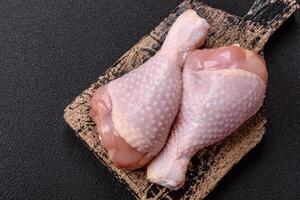 Raw chicken legs with salt, spices and herbs photo