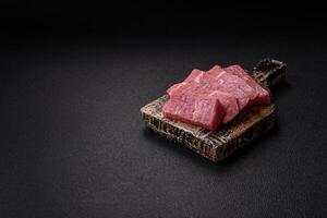 Juicy beef cut into slices with salt, spices and herbs photo