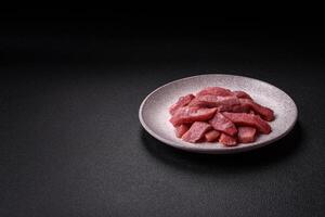 Juicy beef cut into slices with salt, spices and herbs photo