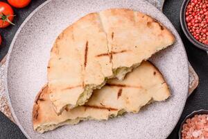Round flatbread or pita with cheese, herbs, salt and spices photo