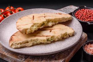 Round flatbread or pita with cheese, herbs, salt and spices photo
