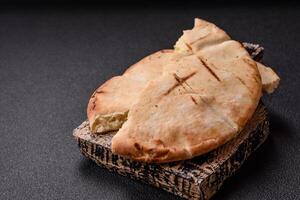 Round flatbread or pita with cheese, herbs, salt and spices photo