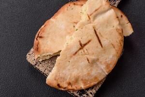 Round flatbread or pita with cheese, herbs, salt and spices photo