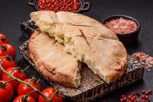 Round flatbread or pita with cheese, herbs, salt and spices photo