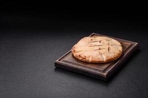 Round flatbread or pita with cheese, herbs, salt and spices photo