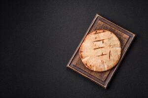 Round flatbread or pita with cheese, herbs, salt and spices photo