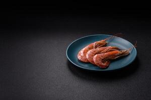 Boiled tiger prawns with salt, spices, herbs and vegetables photo