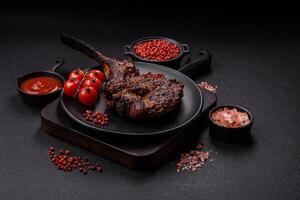 Grilled wagyu beef tomahawk steak with salt, spices and herbs photo