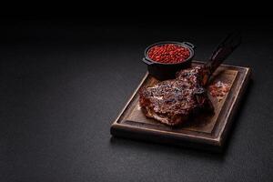 Grilled wagyu beef tomahawk steak with salt, spices and herbs photo