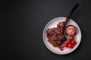 Grilled wagyu beef tomahawk steak with salt, spices and herbs photo